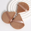 A set of three triangular cosmetic powder puffs in a soft brown suede material with light pink ribbon accents.