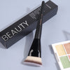 A black flat kabuki foundation brush is shown next to its packaging box.