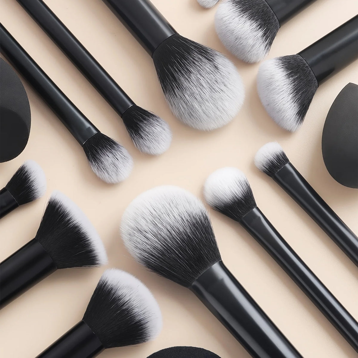 Una colección de doce brochas de maquillaje profesionales en tonos negro y plateado sobre un fondo claro.