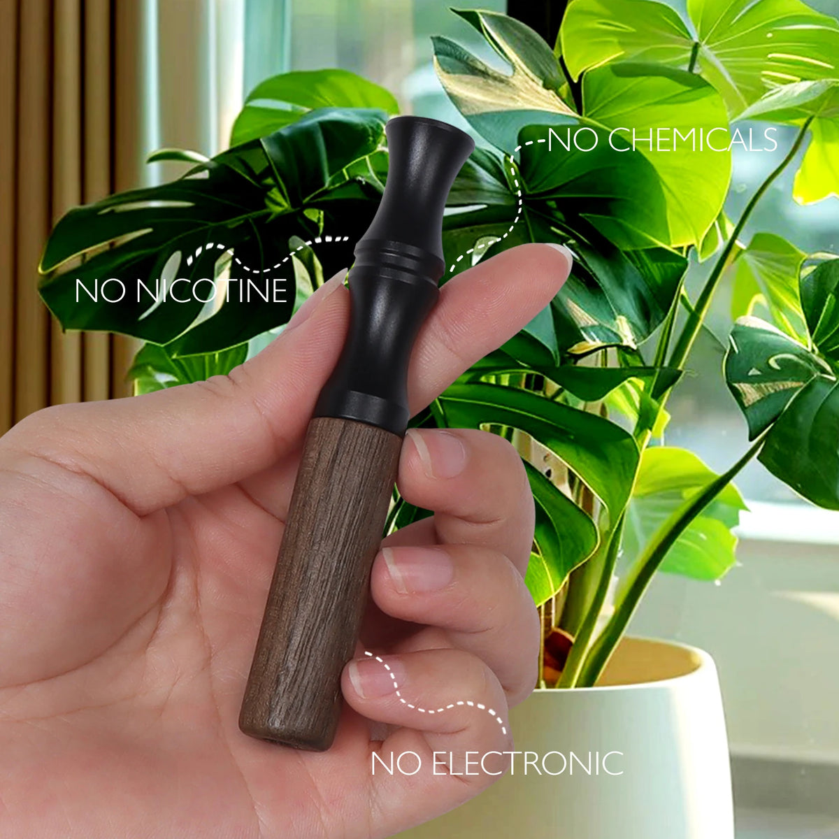 A hand holds a natural wooden stop smoking stick diffuser against a background of green foliage.