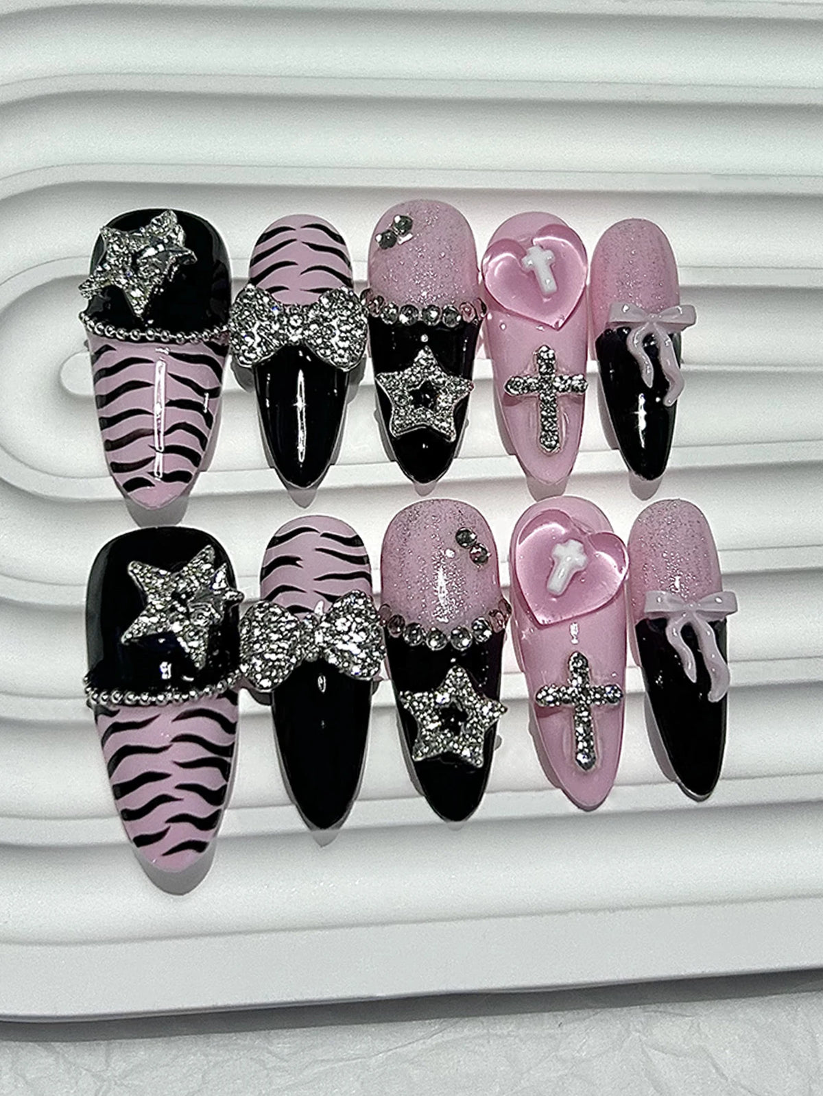 A set of glitter diamond press on nails featuring black, pink, and zebra print designs.