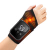 A hand wearing a black wrist brace with orange heating elements and a digital display, used as a heated vibration massager.