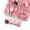 A box of pink press-on nails featuring leopard print and various bow designs.