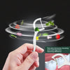 A hand holds a white reusable dental flosser tool demonstrating its use for cleaning.