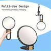 A multi-use handheld makeup mirror with a round magnifying lens shown in various uses like desktop and hanging.