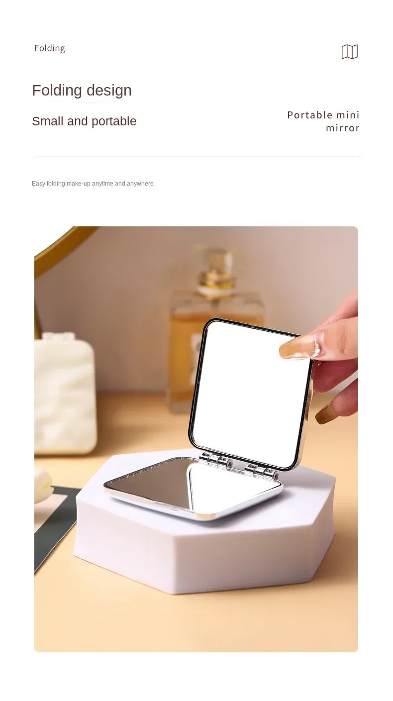 Miroir portable mini à pliage ouvert sur un support blanc.