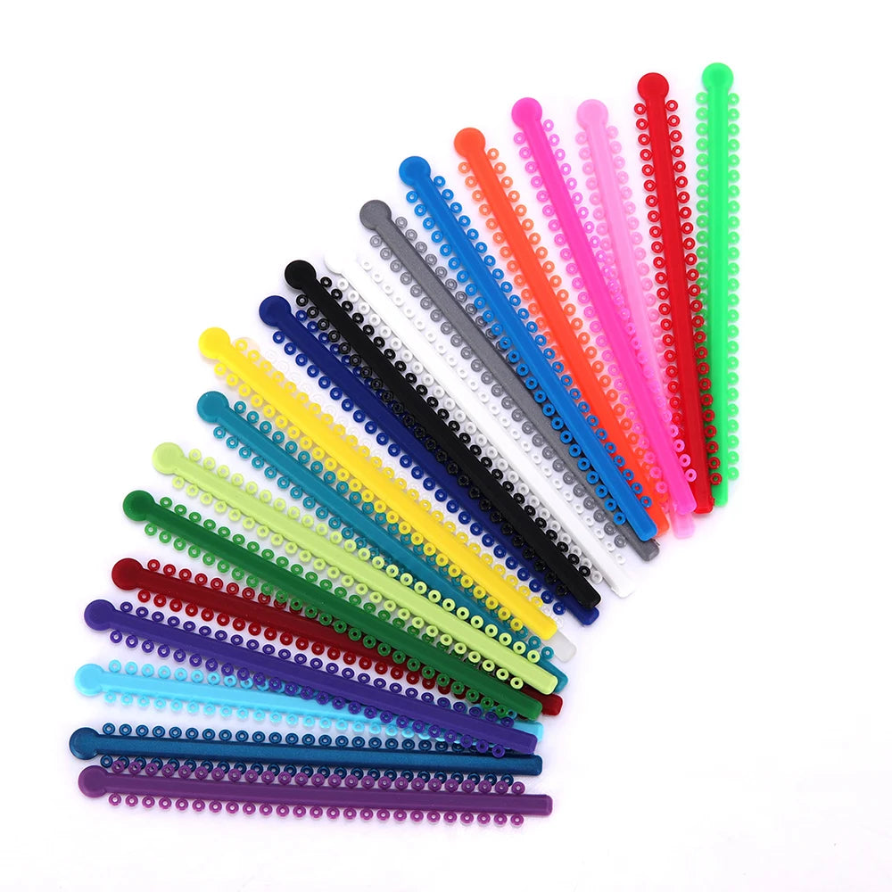 A collection of colorful dental orthodontic elastic ligature ties arranged in a fan shape.