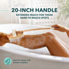 A person is using a 20-inch handle exfoliating brush in a bathtub to cleanse their body.