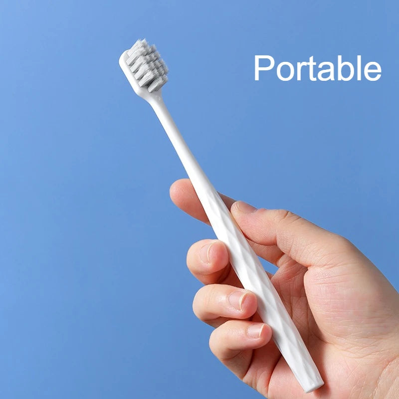 Une main tient une brosse à dents portable blanche, démontrant le produit.