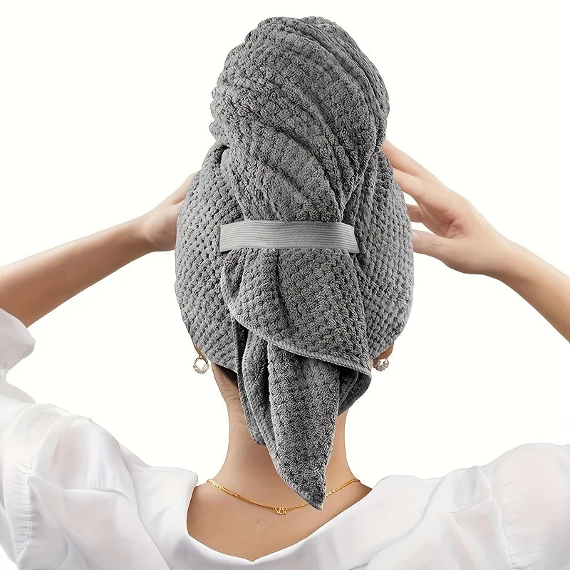 Un foulard de serviette en microfibre grise est posé sur la tête d'une personne, montrant la texture du tissu et son style.