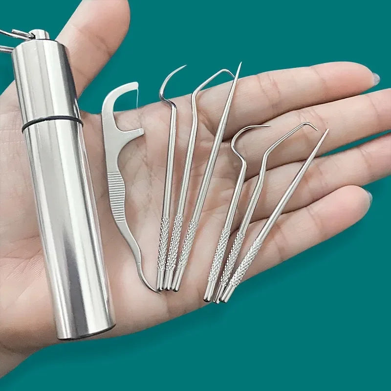 Une main tient un kit de dentifrice en métal réutilisable avec plusieurs curettes métalliques.