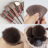 A collection of makeup brushes and a sponge showing various sizes and shades of soft synthetic bristles.
