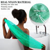 A woman is using a green nylon exfoliating bath sponge with a rope handle in a white bathtub.