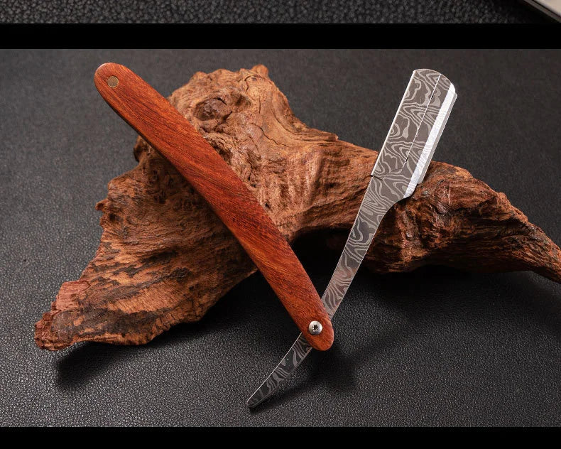 A professional wood handle shaving razor with a dark brown wooden handle and a silver blade resting on a piece of bark.