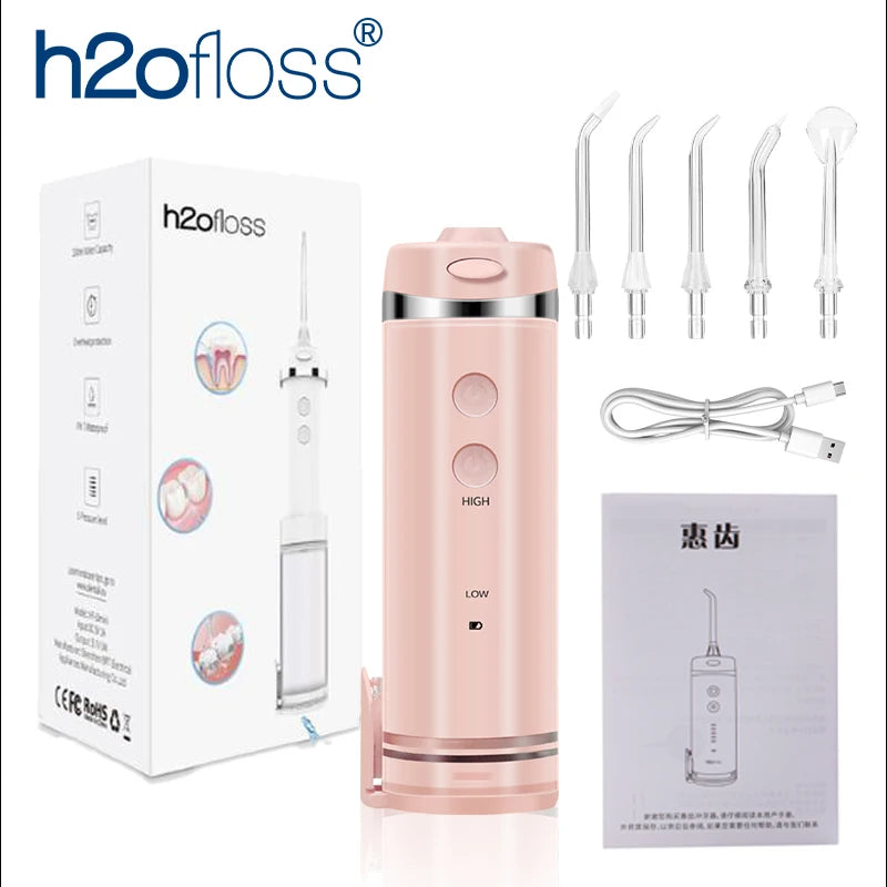 A pink portable water flosser device and its accessories are shown in a box and individually.