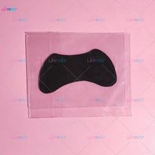 Un coussin protecteur pour relevation de cils en silicone noir est visible à l'intérieur d'un emballage en plastique transpar