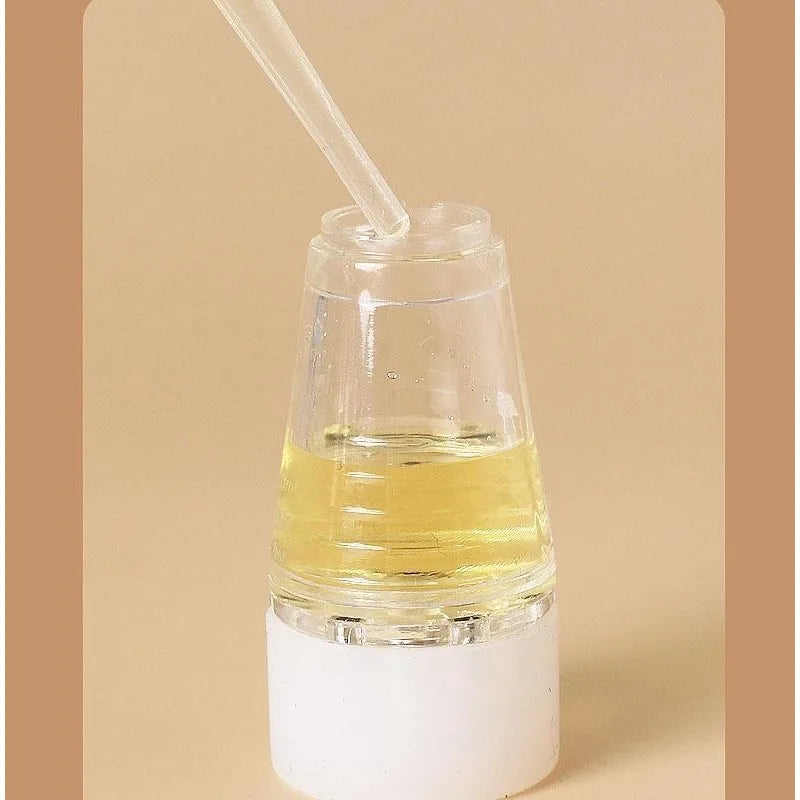 Flacon en verre transparent avec huile essentielle jaune et pipette blanche.