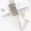 Peigne pour cheveux bouclés beige clair professionnel avec tête en plastique, à côté de sa boîte.