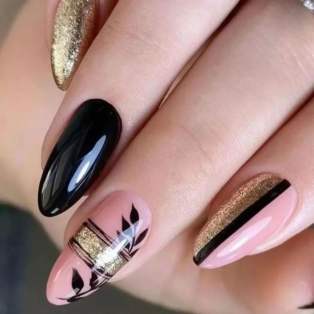 Close-up of a hand displaying press-on false nails with a French wavy design featuring black and gold accents.