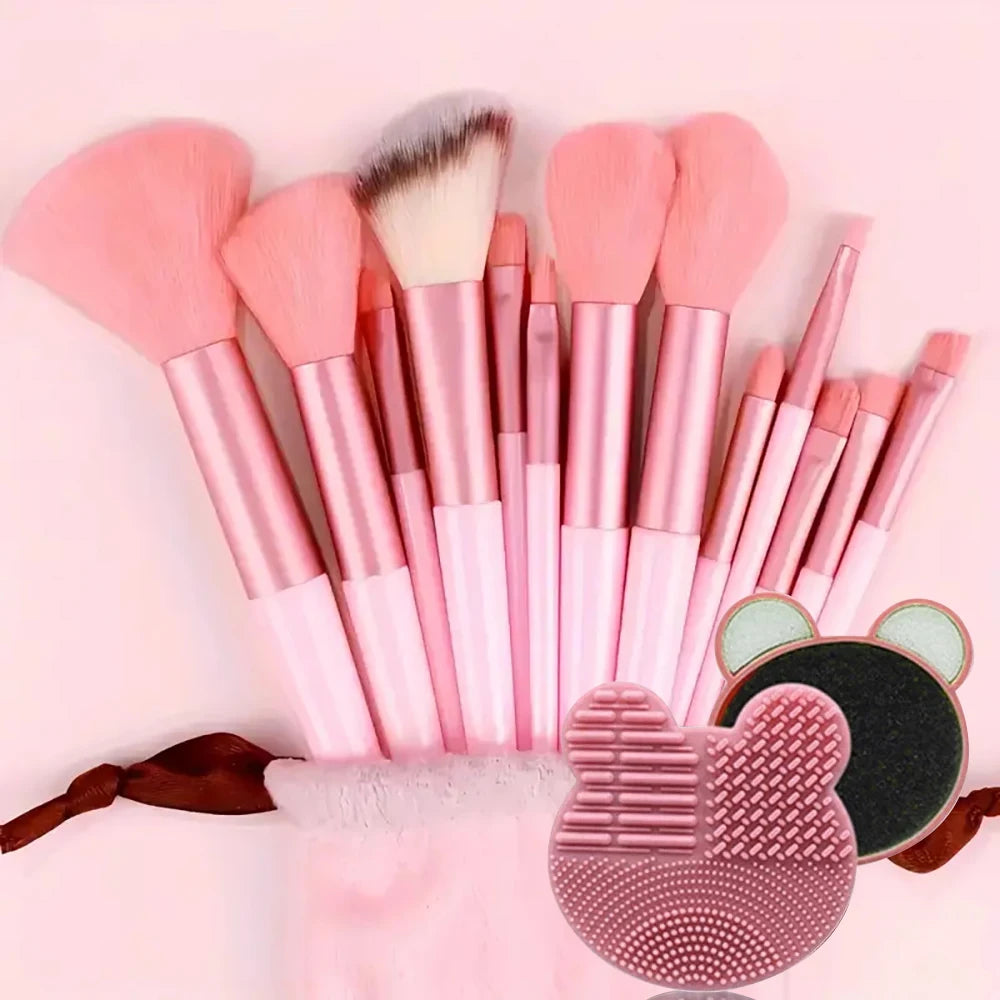 A collection of pink and nude makeup brushes, including various sizes and shapes, displayed on a pink background.