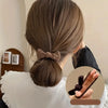 Primer plano de una mujer atando un lazo de cabello marrón, mostrando las penyas para el cabello dulces.