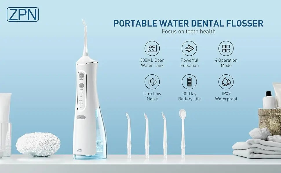 A white portable water dental flosser device is displayed on a counter with various dental tools and accessories.