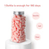 A glass jar filled with pink earplugs, with text indicating one bottle lasts for 180 days.