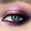 Primer plano de un ojo con maquillaje de sombra de ojos morada brillante y con purpurina.