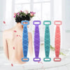 A person's back shows various colored silicone body scrubbers or back brushes for massage and cleaning.