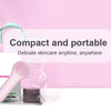 Cepillo facial de silicona eléctrica rosa dentro de una bolsa plástica transparente sobre una superficie blanca.