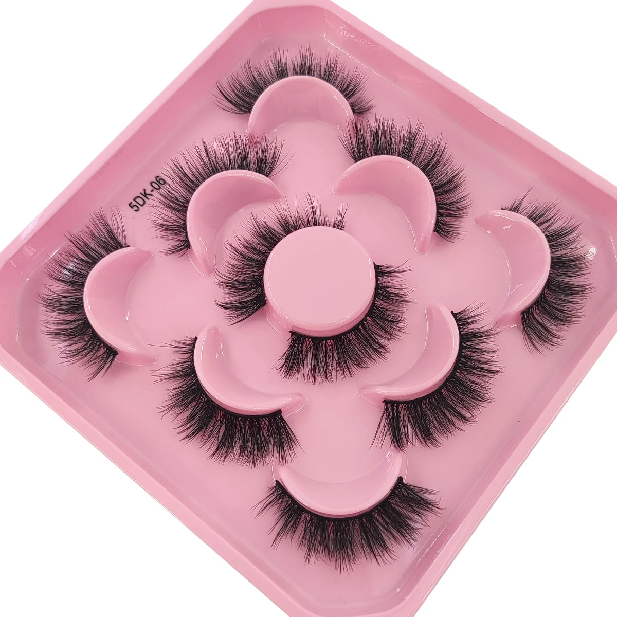 A pink tray holding a set of artificial mink eyelashes for eye extensions.
