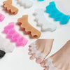 Various colored silicone toe separators placed on a white background and a foot wearing one.
