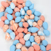 A pile of reusable expandable makeup sponges in various pastel shades of pink, orange, and blue.