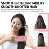 Eine Frau benutzt eine rosa Haarbürste, um ihr langes, dunkles Haar zu glätten und zu ordnen.