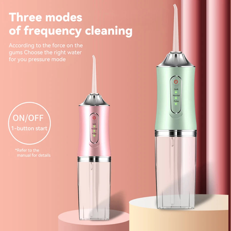 A pink and green USB rechargeable dental flosser device is shown standing on a light pink surface.