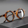 Une paire de lunettes à tortoiseshell marron posée sur une surface sombre.