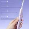 A hand holds a purple sonic electric toothbrush with a white brush head, demonstrating its various cleaning modes.