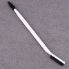 A white dual-ended eyelash curler and brow brush set lying on a gray surface.