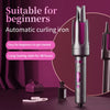 A professional rotating curling iron in silver and purple is displayed on a dark surface with hair accessories.