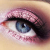 Primer plano de un ojo con sombra de ojos metálica y brillante color rosa.