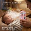 A baby is using a pink portable mesh nebulizer to inhale a soft mist in a dimly lit indoor setting.