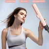 A woman is using a pink hair straightener and dryer on her hair.