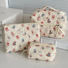 A set of quilted cotton makeup bags featuring a floral pattern and small teddy bear designs, displayed on a white surface.