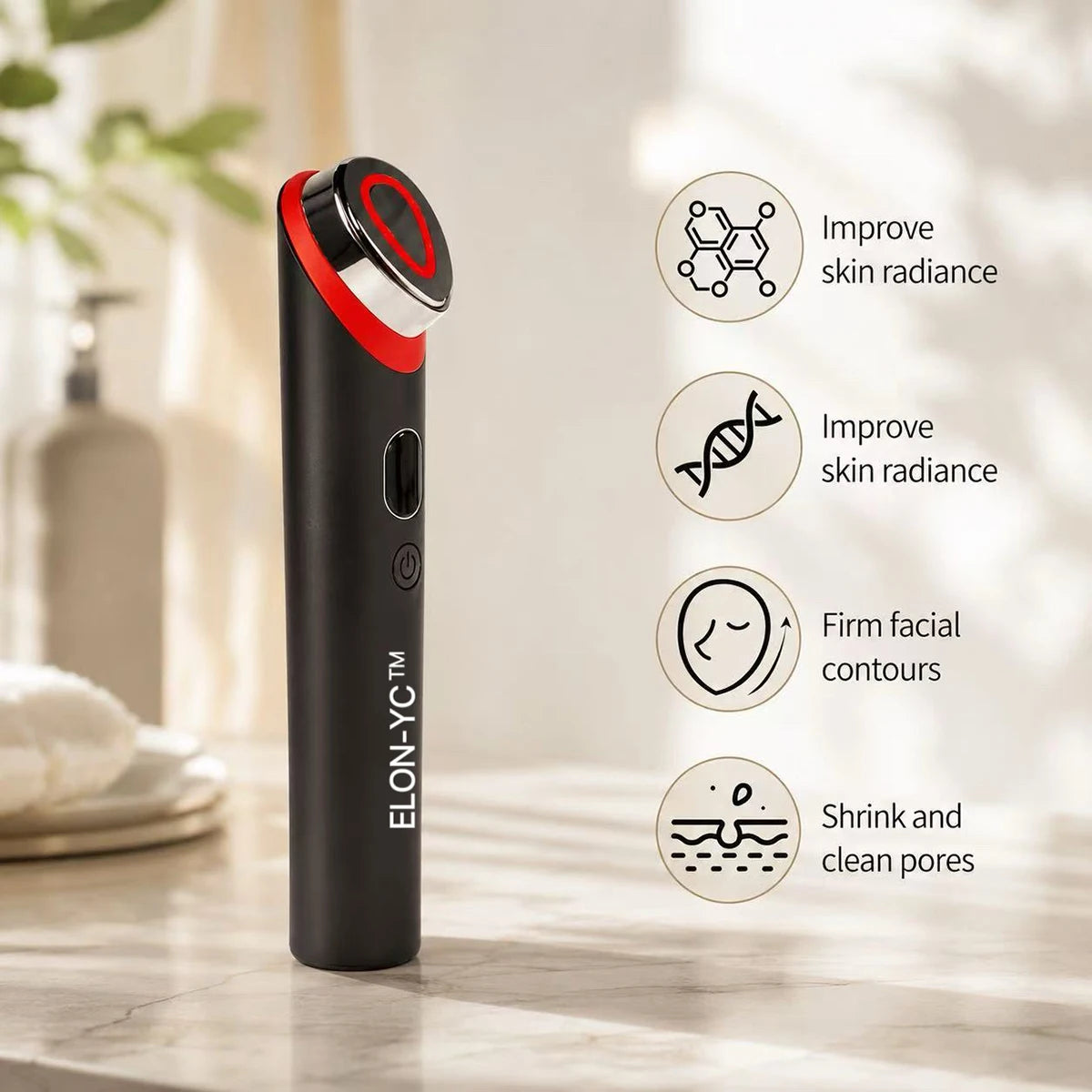 A black microcurrent facial massager with a red and white cap is shown on a marble surface.