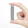Une main tient un petit produit de voyage cylindrique en argent, montrant sa longueur pliée.