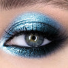 Primer plano de un ojo con sombra de ojos metálica azul brillante y con purpurina.