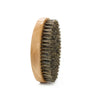 A wooden comb with boar bristles used for beard and mustache grooming.