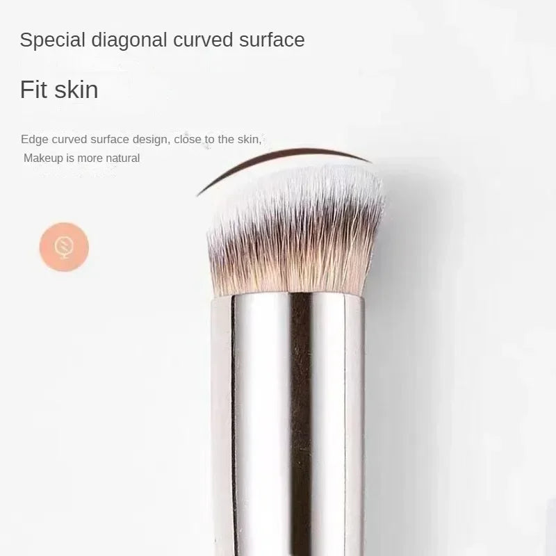 A close-up of a silver makeup brush with a special diagonal curved surface.