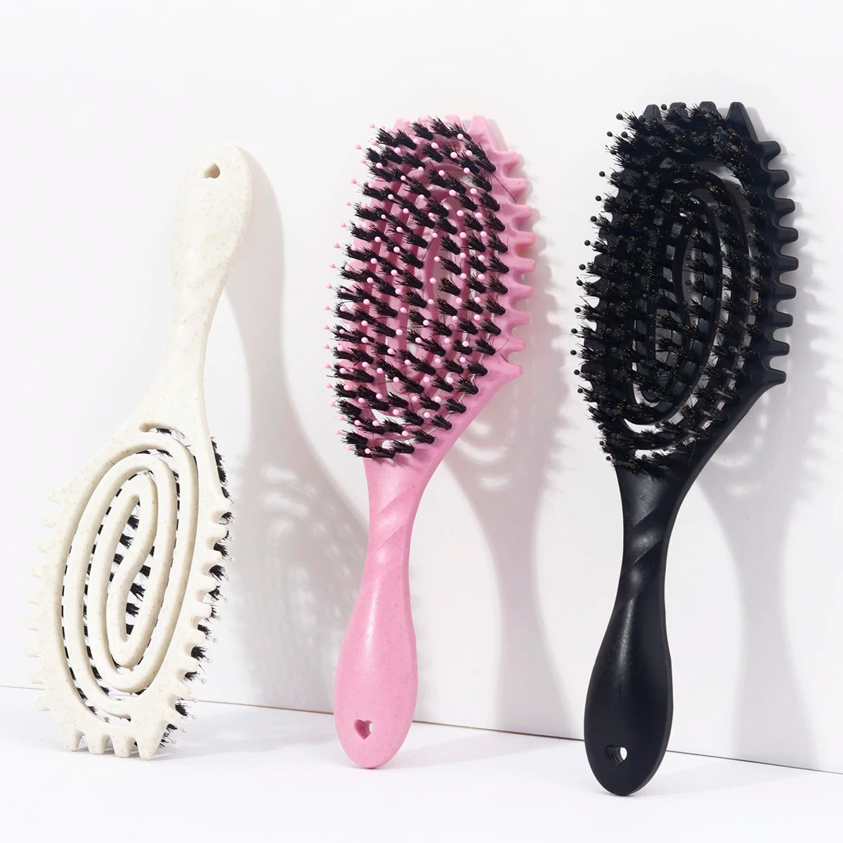 Three styling combs: a white spiral comb, a pink comb, and a black comb.