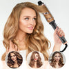 A woman is using an electric hair curling comb to style her blonde hair.